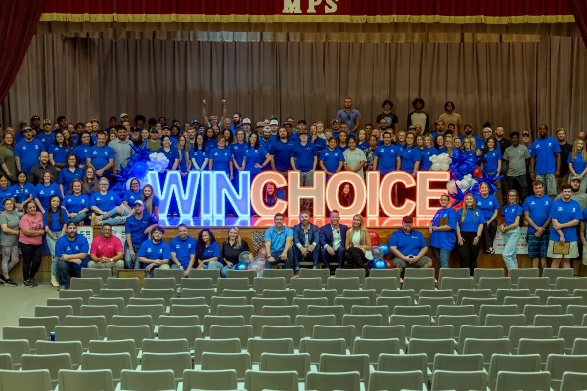 Winchoice Blog - Window and Roofing Guides - Sidebar Image Winchoice team surrounding red & blue letters at employee appreciation event in 2025